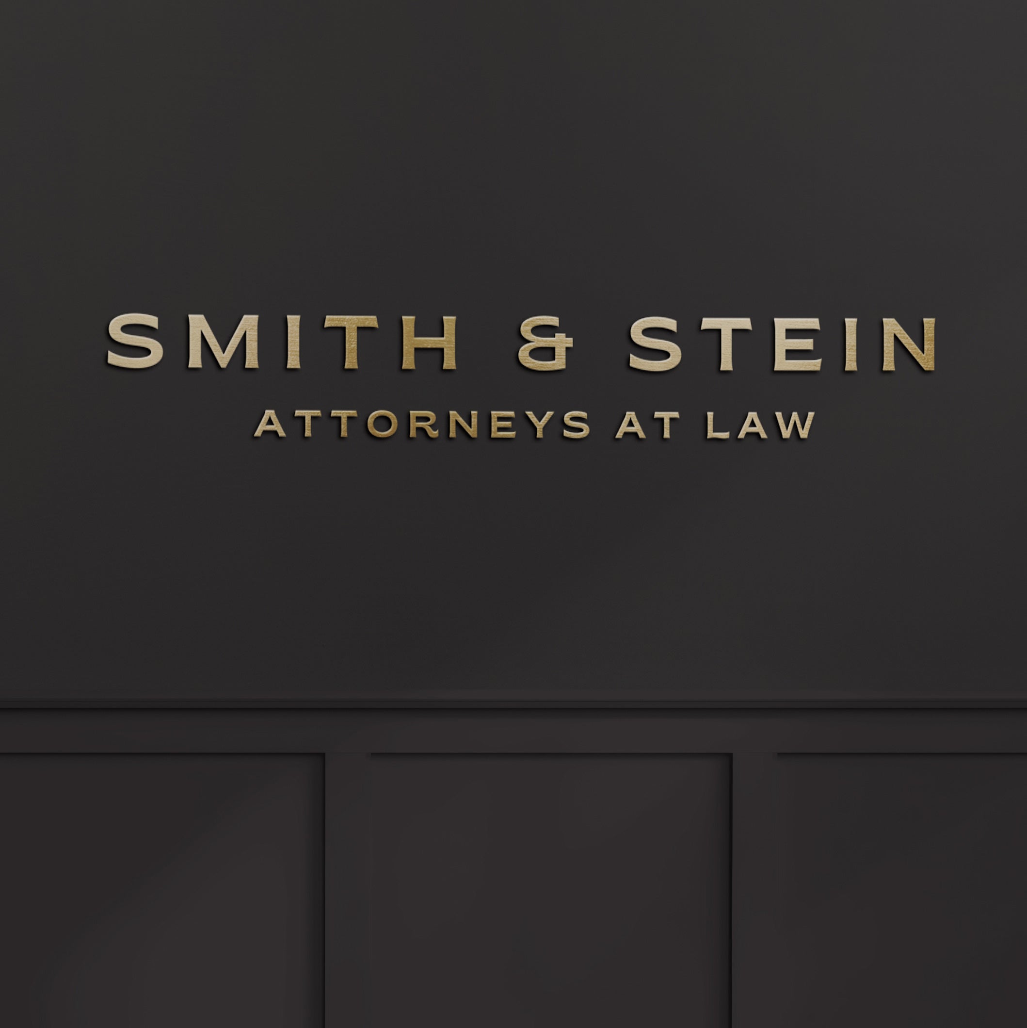 Brushed gold logo of Smith & Stein Attorneys at Law on a black wall.