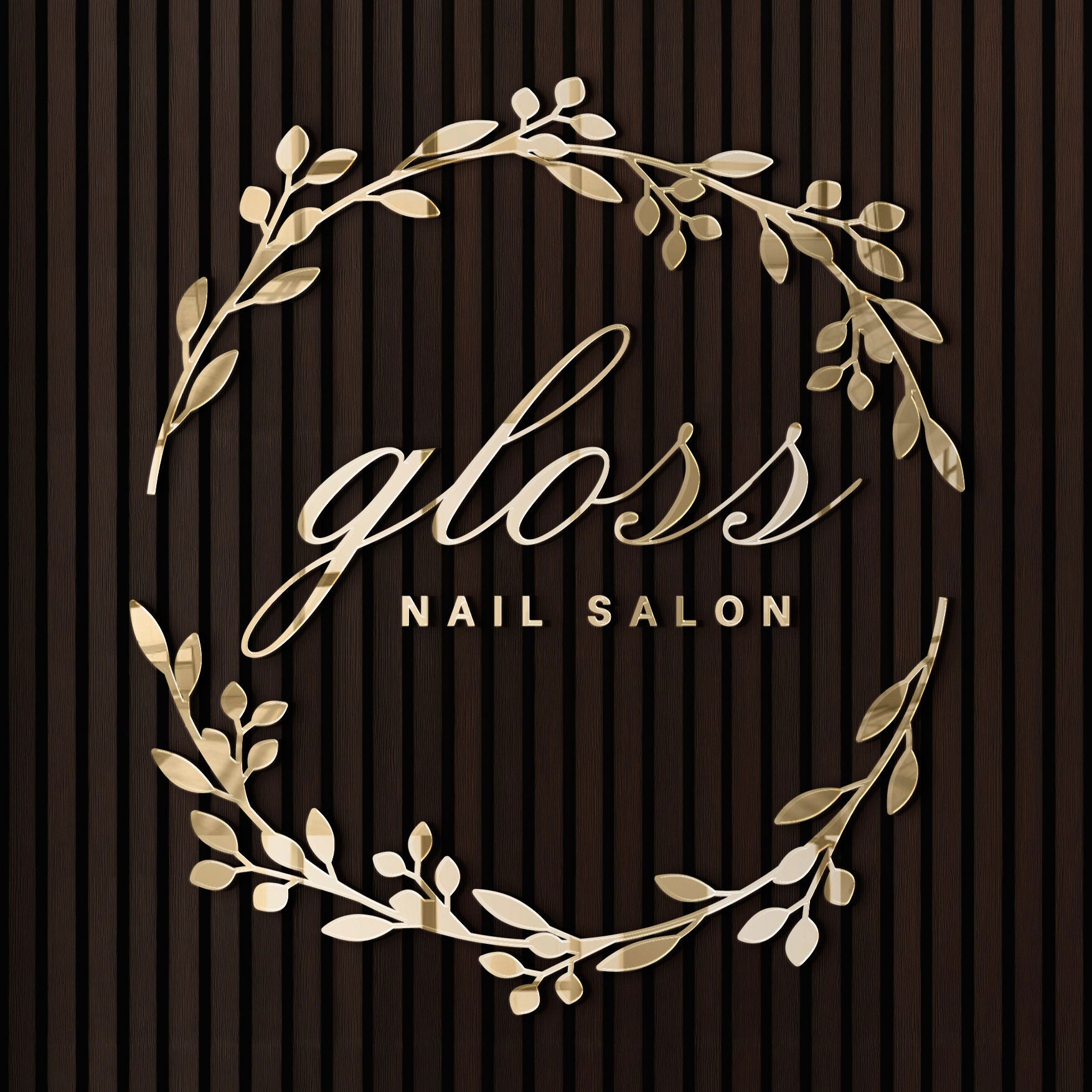 Gloss Nail Salon gold mirror lobby logo with decorative leaves on a brown wall.